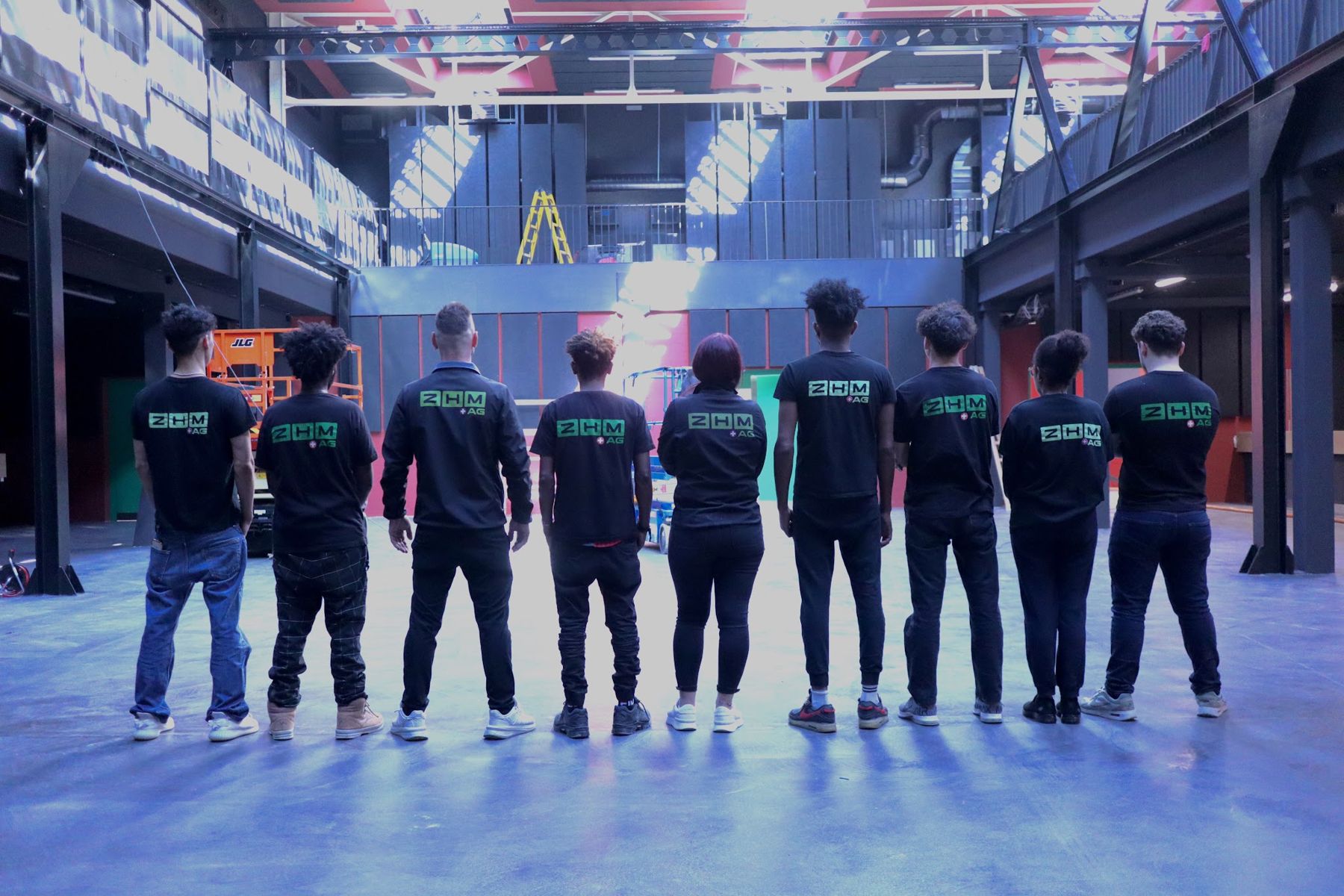 Das ZHM Team in schwarzen ZHM Shirts in einer grossen Halle